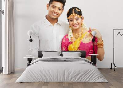 Attractive happy south Indian couple in traditional dress on white. Wall mural