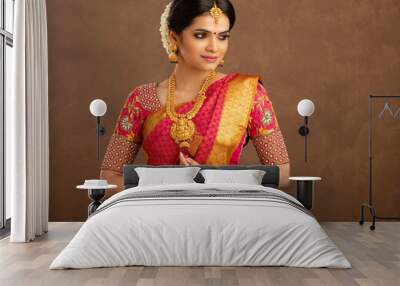 Beautiful Indian young Hindu Bride against brown background in studio shot Wall mural