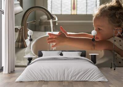 Cute little toddler girl washing her hands Wall mural