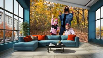 Grandmother and two young granddaughters exploring nature and collecting leaves Wall mural