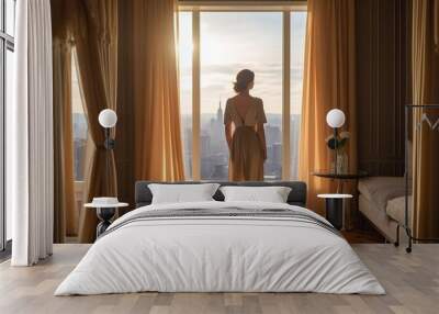 Rear view of a woman standing at the window of a modern, luxurious apartment or hotel room.  Wall mural