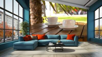 two cups of coffee  on table over sea landscape with sunlight. Beauty nature background Wall mural