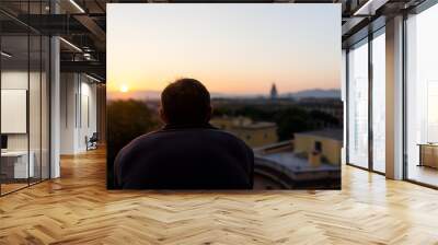 Back of young man watching sunset in Rome, Italy historic city with church tower, summer evening sunset night cityscape skyline, mountain aerial view of rooftops Wall mural