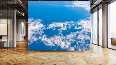 Isolated sky cloudscape with fluffy cloud and vibrant blue Atlantic ocean sea on aerial high angle view of from airplane during sunny day Wall mural