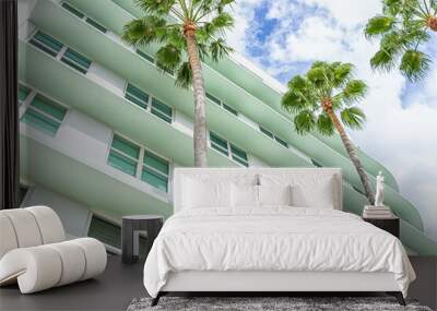 Miami Beach, Florida colorful pastel green house apartment building with Art Deco district style architecture looking up on palm trees and windows Wall mural