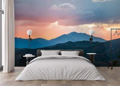 Orange red cloudy sunset sun rays in Aspen, Colorado with rocky mountains peak and vibrant color of clouds at twilight with mountain ridge silhouette Wall mural