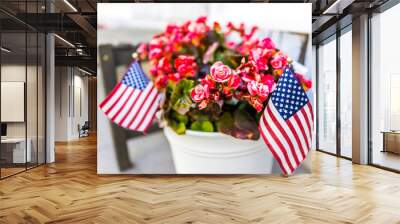 Patriotic flower pot with American flags and pink or red begonia flowers on porch Wall mural