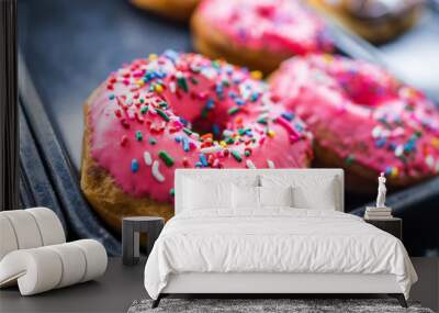 Pink iced donuts with rainbow sprinkles Wall mural