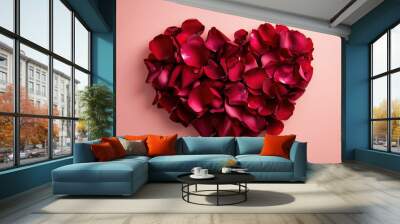 Heart shaped, made of red petals, laid on white sand with blue ocean in the background, symbolizing love and romance. Wall mural