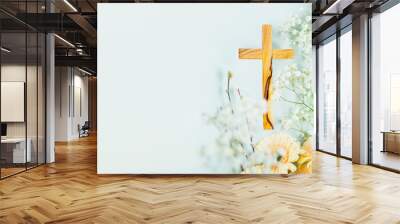 Wooden cross with spring flowers on blue background with copy space. Religion background. Religious church holidays. Christianity Feast, Easter, Palm Sunday, Christening, church wedding. Flat lay Wall mural