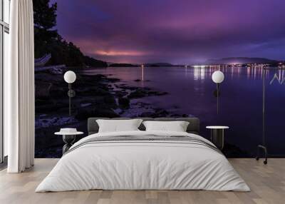 sunset purple blue night at sea with city lights in far away horizon Wall mural