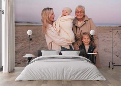 Happy family of mother and grandmother with children together on the beach Wall mural