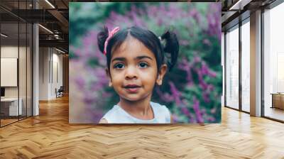 close up beautiful indian little girl in the park with trees and greenery Wall mural