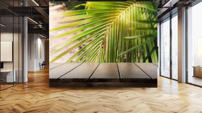 Dark wood table top (Bar) with blur on green palm leaves or tree in tropical forest with bokeh light at background Wall mural