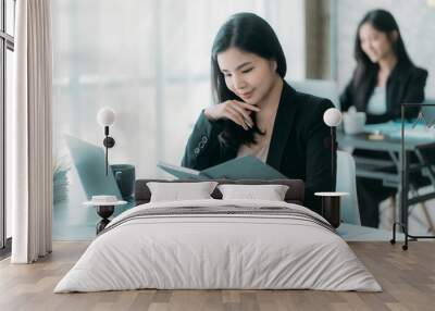 Businesswoman or accountant using the phone to check business information. Accounting Documents and Laptop Computer at Office Business Ideas Wall mural