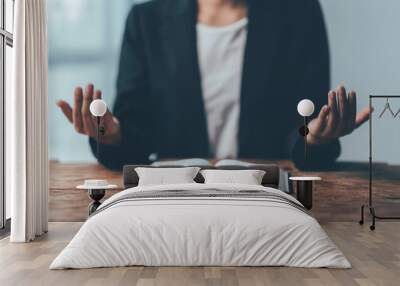 Hands Raised in Prayer: A close-up photo of a person's hands raised in prayer, with an open bible in front of them. The image is composed with a warm, inviting light that creates a peaceful and spirit Wall mural