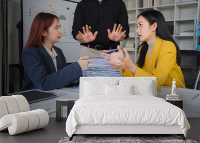 Office Conflict: Two businesswomen engage in a heated disagreement, while a male colleague attempts to mediate. The scene depicts workplace tension and the challenges of communication. Wall mural