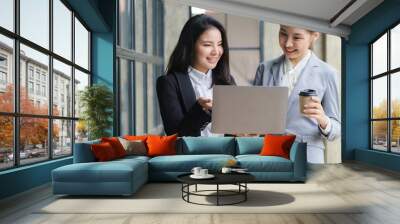 Two business Asian young women working together with laptop computer in the modern office. Wall mural