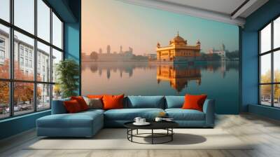 A sacred Sikh gurdwara with its golden dome reflecting in a calm water body, under a clear sky. Wall mural