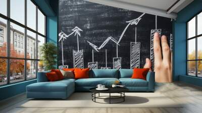 Financial growth chart drawn by fingers on a blackboard, with clear upward arrows and marked profit lines. Wall mural