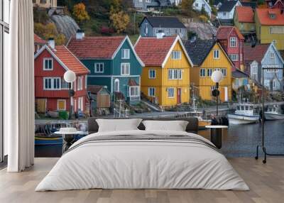 Vibrant, multicolored houses in a picturesque seaside village, with fishing boats anchored in the harbor. Wall mural