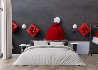 Red Santa Claus hat with white fur trim, isolated on a wooden background Wall mural