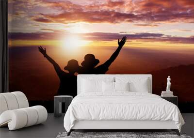 Silhouette of couple on the top hills and sky sunset background Wall mural