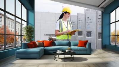 Female engineers work at precast wall factories or work at construction sites. Wall mural