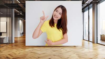 smiling girl pointing finger to present Wall mural