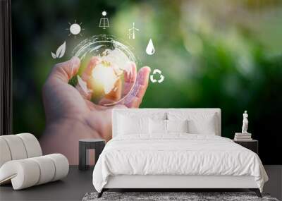 Hand holding virtual global with green background, energy saving concept, alternative and renewable energy, environmental protection and conservation , natural resources preservation. Wall mural