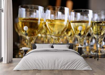 Closeup of glasses of white wine in a row on a table Wall mural