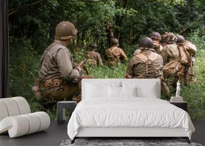 Historical reeneactors dressed As  american  Infantry Soldier during  World War II  patrol the forest. View from the back. Porąbka, Poland Wall mural