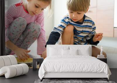 happy family make food at home. little kids son and daughter helps his mother cooking pizza in the kitchen. concept pastimes of isolation time in quarantine mode during coronavirus covid-19 Wall mural