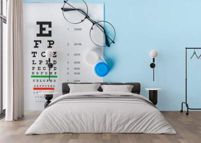 A table for checking vision in Russian, glasses and lenses on a light blue background. a concept for an ophthalmology clinic or the sale of optics Wall mural