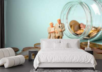 Miniature people stand on coins. Elderly people and their savings, pension Wall mural