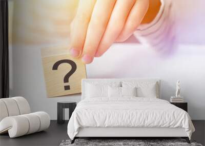 Close-up hand of a child holding the question mark on wooden block cube on white table background, copy space. The concept of choice, decision making, solve a problem, find answer. Wall mural