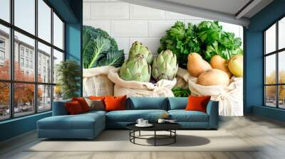 Kitchen surface with various fresh vegetables and fruits in eco-friendly fabric bags Wall mural