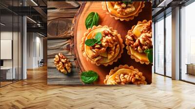 Mini Apple pie tartlets with walnut on wooden table. Delicious dessert for autumn winter dinner Wall mural