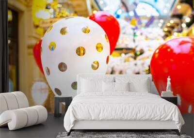 Round white with a golden helium air balloon in the background of a group of red colors. Decorations in the mall, festive window dressing for Christmas and Valentine's Day. Wall mural