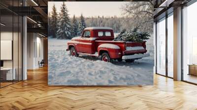 Vintage red truck with Christmas tree in the snow-covered landscape at sunset Wall mural