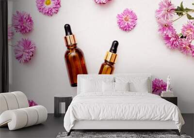 Flat lay of droppers glass bottle skincare essential oil products for mock up in minimal style with on white background with flowers chrysanthemums. Wall mural