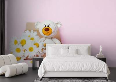 Toy teddy bear in a craft box with daisies isolated on a pink background. Baby background. Copy space, top view Wall mural