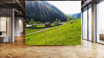 A house by the river in a mountain valley consecrated by the sun. Wall mural