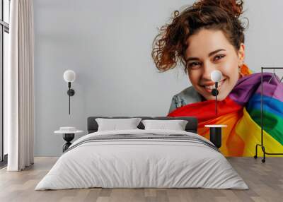 lesbian woman 20s wrapped in colorful striped flag look camera isolated on plain pastel light background. People lgbtq lifestyle fashion concept Wall mural