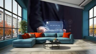 Businessman is using electronic credit card on mobile on virtual screen. The concept of using virtual credit cards in business and online commerce. Wall mural