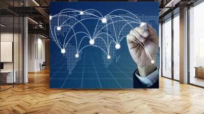 Businessman hand holding electronic pencil or stylus drawing international routes or connection on dotty world map with blue background.  Wall mural