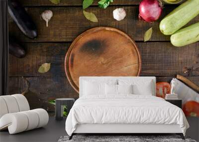 Around the round kitchen board different vegetables, top view Wall mural