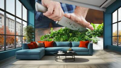 Close up male hands chopping fresh parsley Wall mural