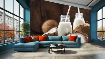 Coconut milk in bottles on wooden table. Healthy eating concept Wall mural