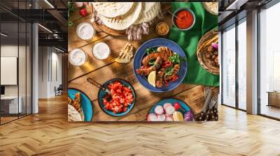 Dinner table with grilled sausage, tortilla, beer and different dishes Wall mural